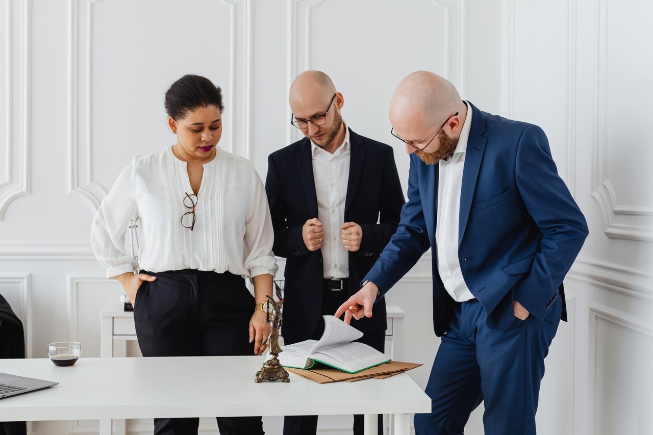 Three professionals reviewing documents together
