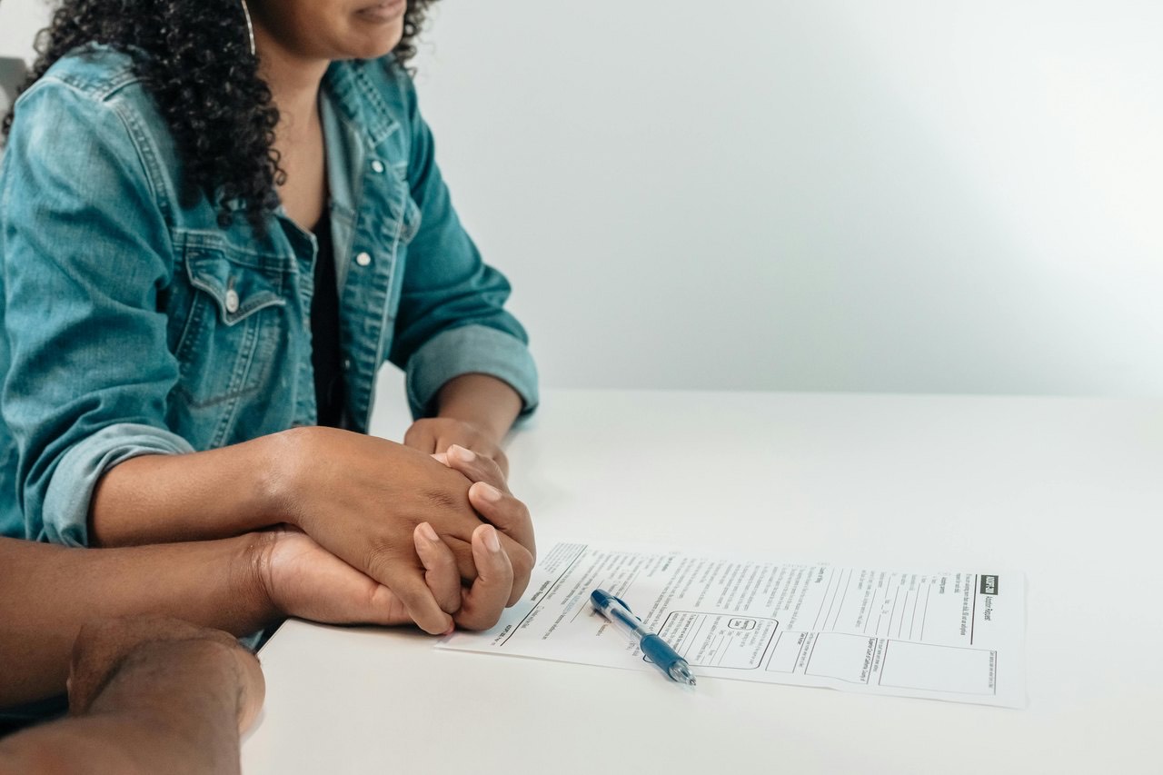 Hands resting on a document during a signing meeting